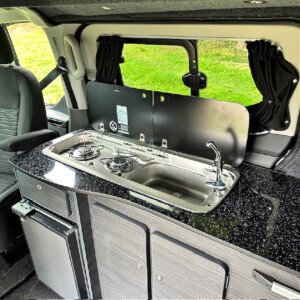 Ford Custom Sliding Window, Blackout Curtain, Kitchen Unit, 2 Burner Gas Hob, Sink With Chrome Tap, Dmetic CRE50 Fridge & LED Interior Spot Lights 2 Day Van Conversions